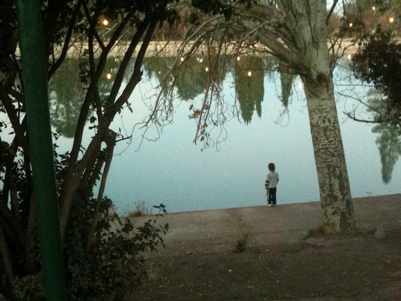 Kid standing by pond in the park in Mendoza