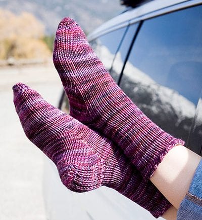 Purple toe-up socks with heel flap, shown out of car window