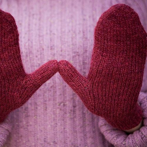 Red magic loop mittens with hands held palm out showing thumb