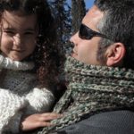 Man with chunky mistake-rib scarf holding daughter