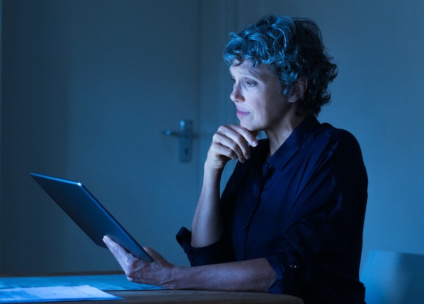 Senior woman working on screen late at night