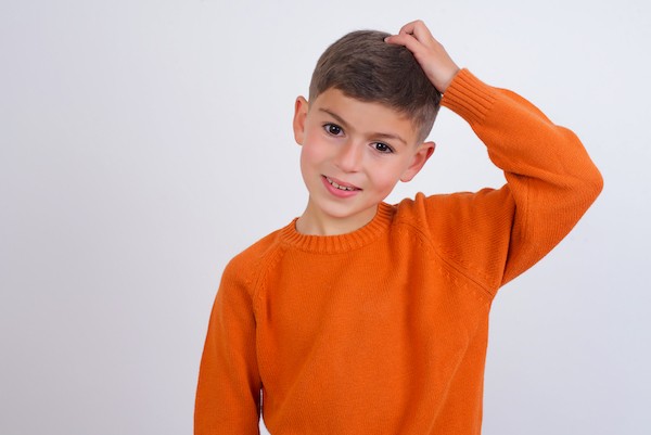 StockImage Confused kid in orange knit sweater V1 61922 sm