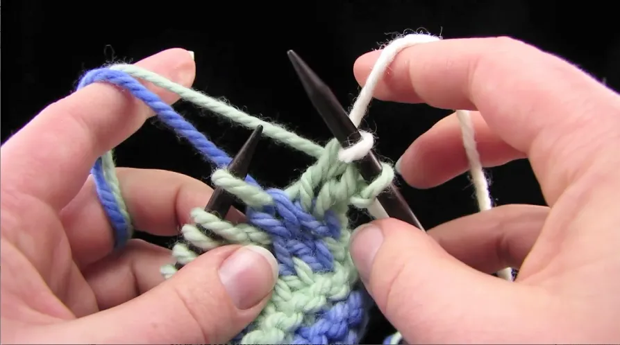 Fair Isle knitting three colors hands closeup