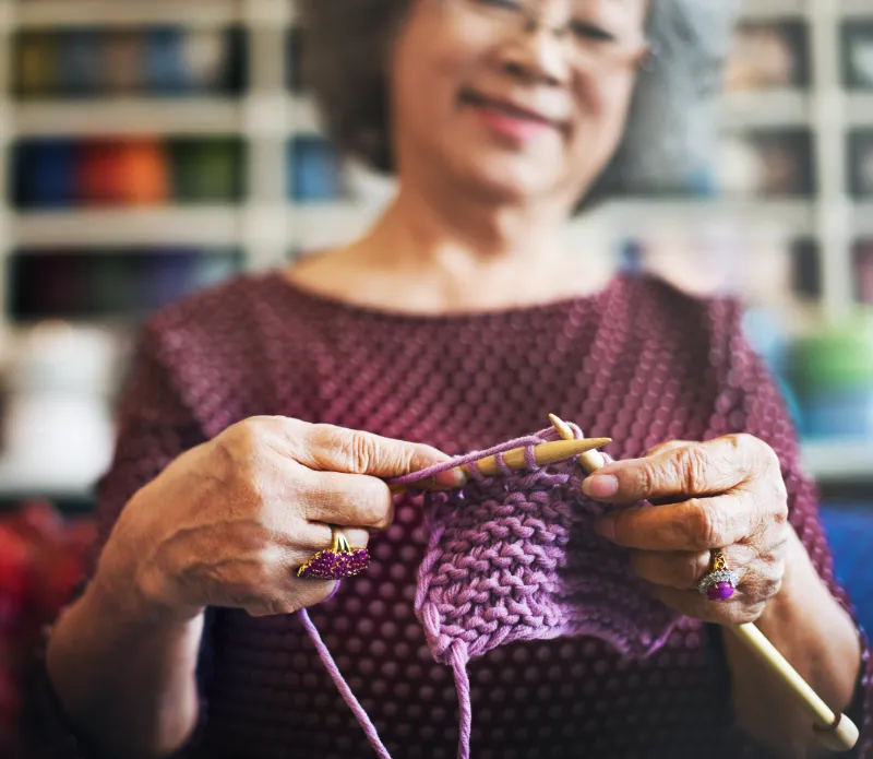 Woman proudly holding her knitting